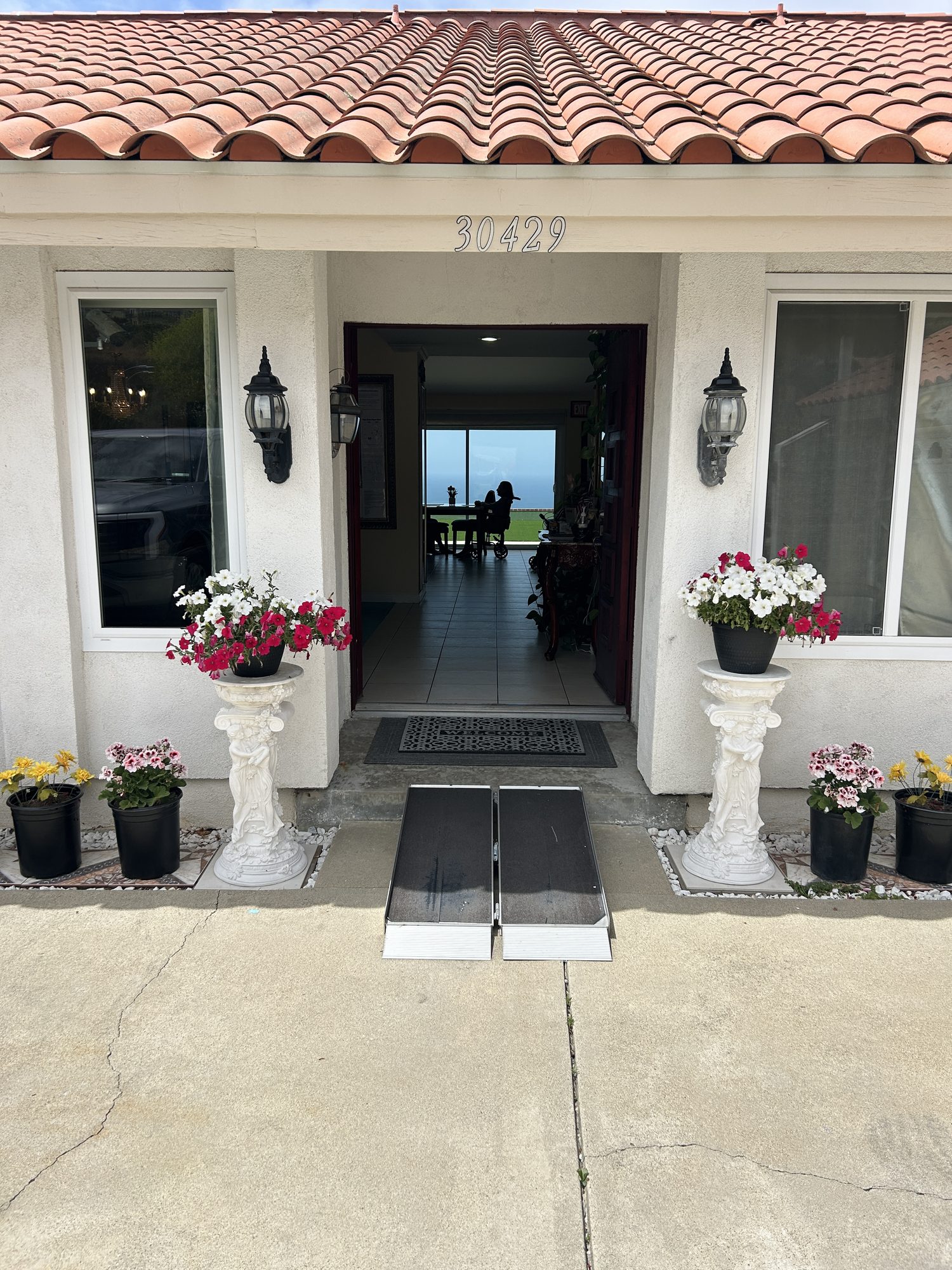Welcoming front entrance with flowers and a wheelchair-accessible ramp